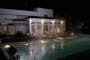 uma pessoa a nadar numa piscina à noite em Masseria Rifisa AgriResort em Caprarica di Lecce
