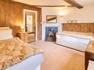 a bedroom with two beds and a fireplace at Host & Stay - The Bell House in Canterbury