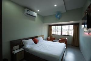 a bedroom with a bed and a window at Haksons Residency in Mananthavady