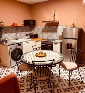 cocina con mesa, sillas y nevera en Le Riad Private Pool, en Saint-Pierre