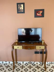 TV en una mesa de madera en una habitación en Le Riad Private Pool, en Saint-Pierre