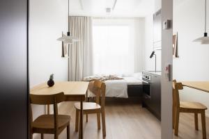 um pequeno apartamento com um quarto, uma mesa e cadeiras em Noli Otaniemi em Espoo