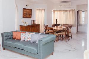 ein Wohnzimmer mit einem blauen Sofa und einem Tisch in der Unterkunft Luho 41 Penthouse in Bangalore