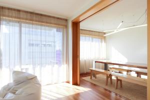 uma sala de estar com um banco e uma grande janela em HM - Ocean Breeze Delight em Matosinhos
