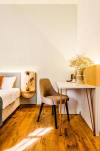 a bedroom with a bed and a table and a chair at CASA CHITIC - HOTEL & RESTAURANT- Str Nicolae Balcescu 13 in Braşov