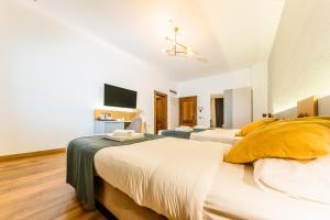 a bedroom with two beds and a flat screen tv at CASA CHITIC - HOTEL & RESTAURANT- Str Nicolae Balcescu 13 in Braşov