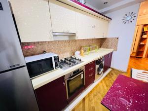 y cocina con microondas y fogones. horno superior en Ganclik apartment by Baku housing en Bakú