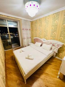 1 dormitorio con cama y lámpara de araña en Ganclik apartment by Baku housing en Bakú
