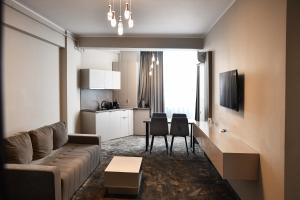 a living room with a couch and a kitchen at Azimuth Hotel By Building Stefan Resort I Nord in Mamaia Sat/Năvodari