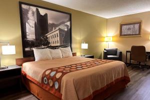 una habitación de hotel con una cama grande y una silla en Super 8 by Wyndham Bellefontaine, en Bellefontaine