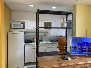 uma cozinha com um frigorífico e uma mesa com uma televisão em Loft completo, Centro Historico 706 em Porto Alegre