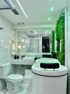 Baño blanco con aseo y lavamanos en apart hotel 2 quartos frente mar, en Salvador