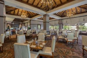 un comedor con mesas, sillas y lámparas de araña en Wyndham Grand Orlando Resort Bonnet Creek en Orlando