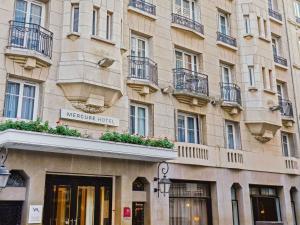 a building with a sign on the side of it at Mercure Paris Opéra Faubourg Montmartre in Paris