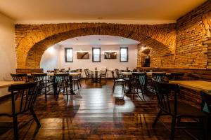 a dining room with tables and chairs and a brick wall at Casa Chitic Hotels in Braşov