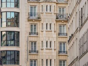 d'un grand bâtiment avec des balcons sur le côté. dans l'établissement Mercure Paris Opéra Faubourg Montmartre, à Paris