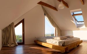 um quarto com uma cama e janelas grandes em Vinczellér Ház em Paloznak