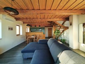 uma sala de estar com um sofá azul e uma mesa em Vinczellér Ház em Paloznak