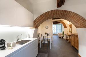 cocina y comedor con un arco de ladrillo en terisuite 14, en Siena