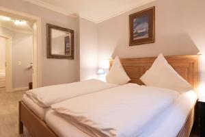 1 dormitorio con 1 cama grande con sábanas blancas en LH Isernhagenhof, App 1, en Wenningstedt
