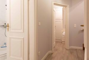 a hallway with a white door and a bathroom at LH Isernhagenhof, App 1 in Wenningstedt +18 photos