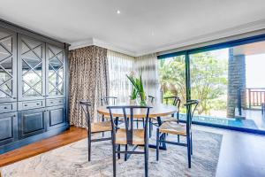 a dining room with a table and chairs at Phezulu Villas 2, Zimbali Estate in Ballito