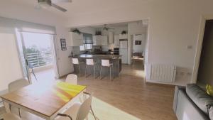 een woonkamer en een keuken met een tafel en stoelen bij STAY Mystique City Penthouse in Limassol