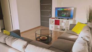een woonkamer met een bank en een tv bij STAY Mystique City Penthouse in Limassol