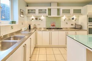 a kitchen with white cabinets and a sink at Host & Stay - Ancient Lights in Broadstairs
