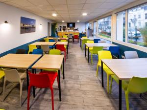 uma sala de jantar com mesas e cadeiras coloridas em Ibis Budget Boulogne-Sur-Mer Centre les Ports em Boulogne-sur-Mer