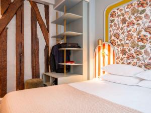 a bedroom with a bed and a wall with a headboard at Mercure Paris Notre Dame Saint Germain des Prés in Paris