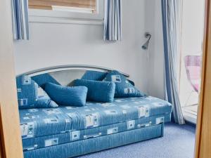 a bed in a room with blue pillows on it at FLOATING HOUSES Classic _ _Schwimm in Barth