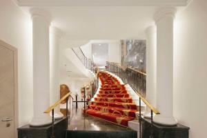 una escalera con asientos rojos en un edificio en NH Collection Madrid Paseo del Prado, en Madrid