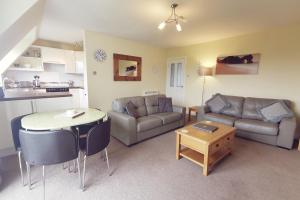 - un salon avec un canapé et une table dans l'établissement 10 ISALLT LODGES - CLOSE TO BEACH - 2 BED APT, à Trearddur