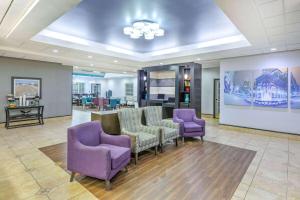 a waiting room with purple chairs and a table at La Quinta by Wyndham Tulsa Airport / Expo Square in Tulsa