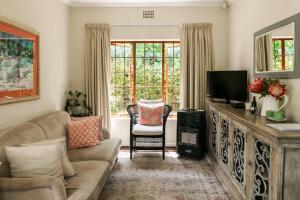 a living room with a couch and a television at Hillingdale on Alexandra in Cape Town