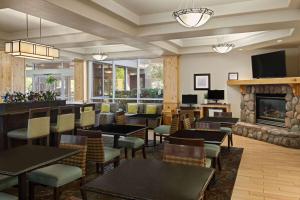 a restaurant with tables and chairs and a fireplace at La Quinta by Wyndham Idaho Falls/Ammon in Idaho Falls