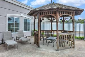 a wooden gazebo with chairs and a table at La Quinta by Wyndham Tulsa Airport / Expo Square in Tulsa