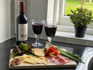 un plato de comida y dos copas de vino en Primrose Cottage, en Moreton