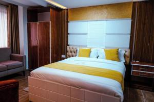 a bedroom with a large bed with yellow pillows at Barre Hotel in Nairobi