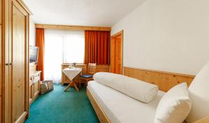 ein Hotelzimmer mit einem Bett und einem TV in der Unterkunft Hotel Astoria in Samnaun