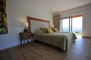 een slaapkamer met een bed met een nachtkastje en een raam bij Villa 272 in Ponte de Lima