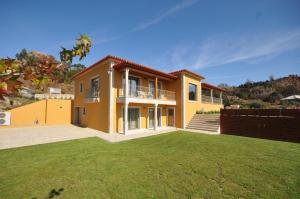 een groot geel huis met een grote tuin bij Villa 272 in Ponte de Lima