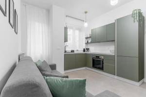 een woonkamer met een bank en een keuken bij Apartment Milan San Siro City Life & Fiera in Milaan