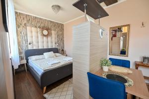 Dormitorio pequeño con cama y mesa en BellaVista 1 Apartman, en Eger