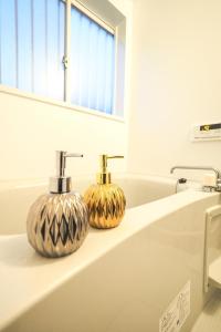 two gold vases sitting on a counter in a bathroom at 【芦ノ湖徒歩10分＆バス停1分】一棟貸切最大14人 大人數BBQ可能 パーティ 『ROUTE99』 in Moto-hakone