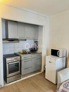 a kitchen with a stove and a refrigerator at Modern Porte de Versailles Flat - Expo Next Door in Vanves