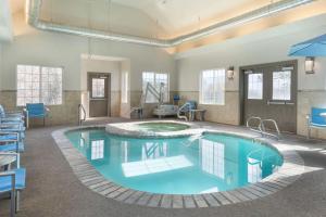 uma grande piscina num quarto com cadeiras azuis em Comfort Inn & Suites Carbondale on the Roaring Fork em Carbondale