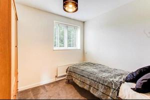 Schlafzimmer mit einem Bett und einem Fenster in der Unterkunft The Wickets - 2 bedroom apartment overlooking cricket club in Marton
