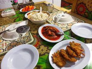 a table with plates of food and bowls of rice at Tangkoko Jungle Homestay in Rinondoran